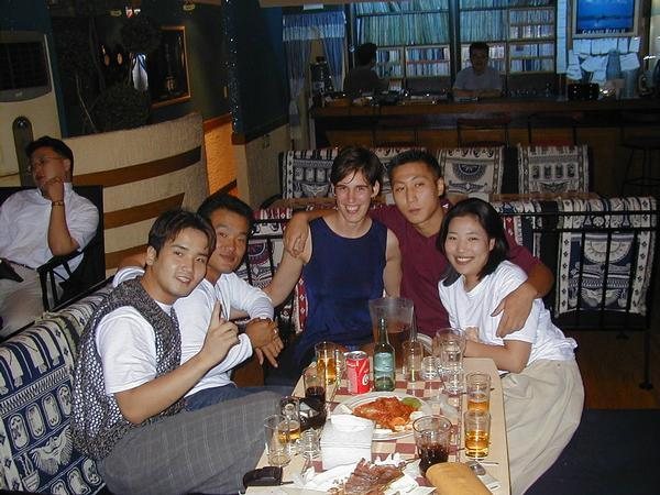 12. 1999년 10월로 기록된 한국 여행 사진. 촬영자가 술집·커피하우스에서 만났다고 설명한 사람들이 맥주와 안주가 놓인 테이블에 함께 앉아 있다.