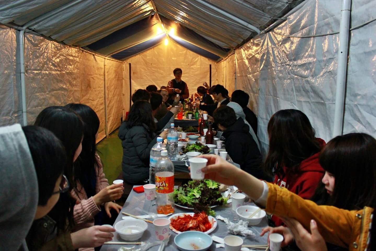 19. 2013년 3월 29일, MT에서 긴 식탁에 모여 저녁을 먹고 잔을 나누는 학생들.