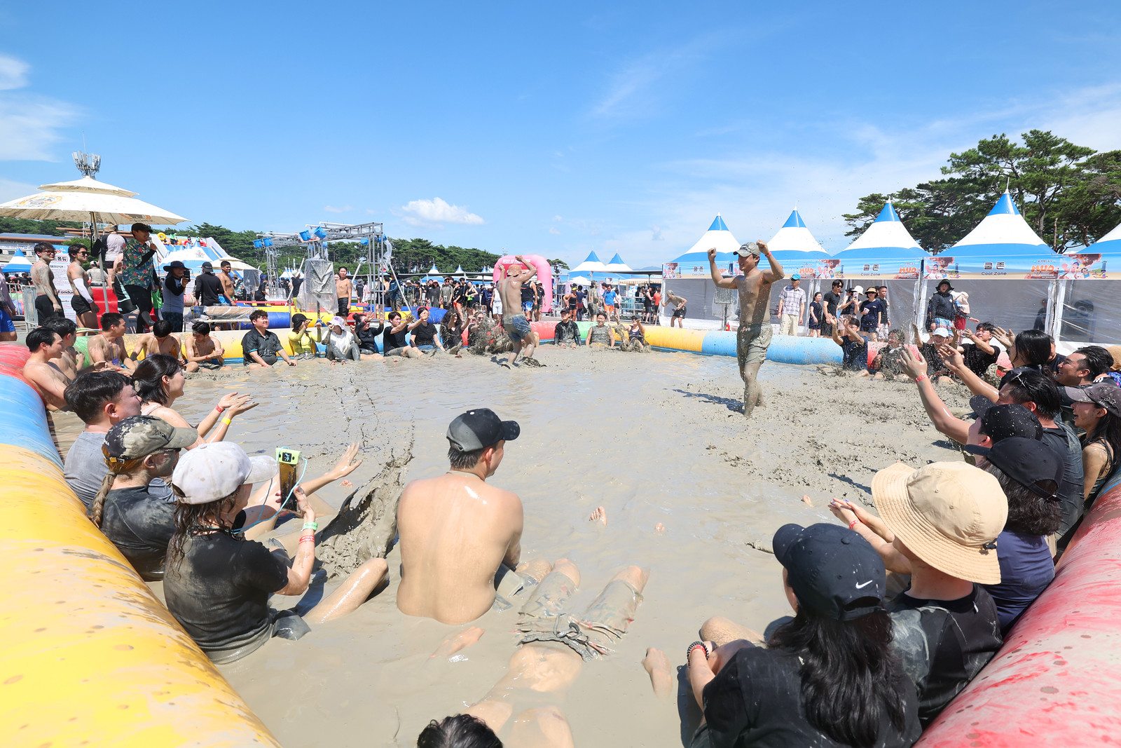 23. 2025년 7월 26일, 대천해수욕장 보령머드축제에서 둥글게 모여 진흙 놀이를 즐기는 참가자들. 사진 속 참가자의 대학 재학 여부는 확인되지 않는다.